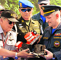 Indonesian and Russian officials with the black box near the crash site of Cijeruk in Indonesia on Tuesday