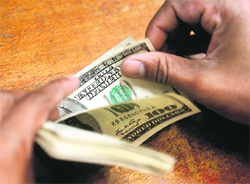 An employee counts US dollars at a foreign exchange dealer's office in Mumbai. The rupee hit a record low against the dollar for a second session in a row on Thursday as global risk assets remained largely under pressure