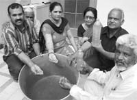 Residents show the muddy water supplied to their houses at the Shivalik Vihar Colony in Zirakpur.