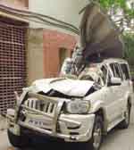 Policemen inspect the car in which the judges were travelling. Tribune photo