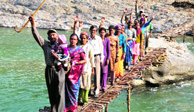 Villagers hold a protest on a wooden bridge on the Ram Ganga near Thal town in Pithoragarh district on Thursday.