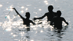 Children search for coins in the Brahmasarovar at Kurukshetra.