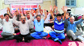 Members of the Kashmiri Migrant Relief Holders and Over Aged Youths stage a protest in front of the Relief Commissioners office in Jammu on Thursday.