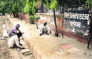 Interlocking tiles being laid on a footpath outside the tehsil complex in Jalandhar on Thursday.