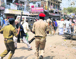 Policemen chase away protesters while boycotting the voting during municipal corporation elections in Patna on Thursday. 