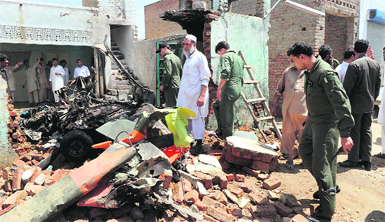 Air Force personnel examine the wreckage of a light Mushshak plane after it crashed in the Rashkai area in Pakistan on Thursday. 