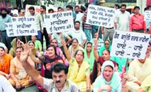 Residents of Sudarshan Nagar hold an agitation outside the Hall Gate area in Amritsar on Friday.