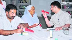 Doctors examine patients during the free eye check-up camp in Amritsar on Friday. 