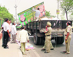 Billboards being removed by the tehbazari wing of the MC in Ludhiana on Friday