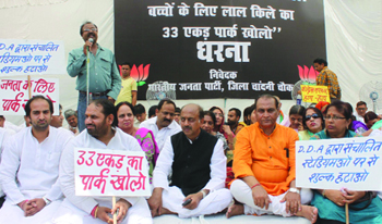 Senior BJP leader and former MP from Chandni Chowk with party activists sits on dharna, asking the Union Sports Minister to open the Red Fort park for children, in Delhi on Saturday.