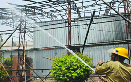 A firefighter douses the fire that broke out at the National School of Drama at Mandi House in New Delhi on Sunday.