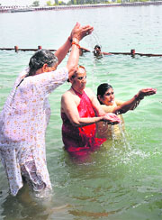 Devotees offer water to the sun god at the Sanhit Sarovar in Kurukshetra on Sunday. 
