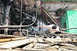 An official of the Fire Department looks at the burnt electricity generator at a building on the Pakhowal Road in Ludhiana on Sunday