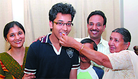 Anish Jindal who shared the top slot is offered sweets by his grandmother in Bathinda on Monday night.