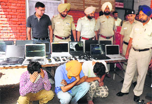 Policemen pose with the theft accused and the goods recovered at the police station in Sector 11 of Chandigarh on Monday.