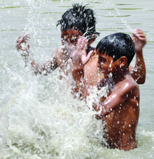 Children enjoy in the Yamuna in New Delhi on Monday.