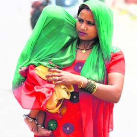 A woman tries to save her child from the scorching sun in Karnal