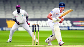 Englands Alastair Cook plays a shot as hes watched by West Indies captain Darren Sammy during the first Test at the Lords in London on Monday.