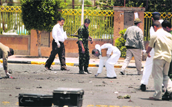 Forensic experts collect evidence at the site of a suicide bomb attack at a parade square in Sanaa on Monday.  Reuters