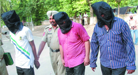 The accused, arrested in the kidnapping case, being led away by the police personnel.