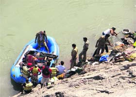 Police and rescue workers take out bodies of the accident victims from the Ganga near Beasi, 40 km from Rishikesh, on Tuesday