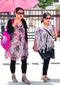 Two girls walk with umbrella as the temperature touched 40 degrees in Haridwar on Tuesday