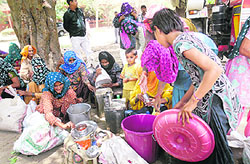 Dalit women prepare to cook food outside the mini-secretariat where they have been camping since they left their houses in Bhagana in Hisar.
