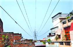 High-tension power cables pass close to houses at Guru Nanak Pura in Jalandhar. 