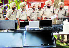 SSP Gurpreet Singh Gill and his team show electronic articles recovered from four persons in Patiala on Monday.