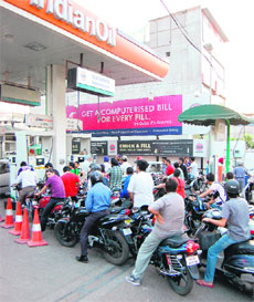 People throng a petrol pump to get a refill of fuel before the Rs 7.50-hike in petrol price from midnight in Amritsar on Wednesday.