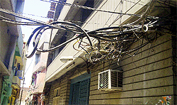 A bunch of power wires hanging precariously near houses