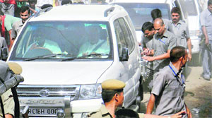 Securitymen scramble to protect Bihar CM Nitish Kumars car after his convoy was attacked with stones by villagers protesting against frequent power-cuts and water shortage, during his sewa yatra in Buxar on Wednesday.