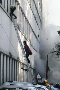 Firefighters rescue women after a major blaze broke out in a building housing Punjab National Bank at Parliament Street in New Delhi on Wednesday