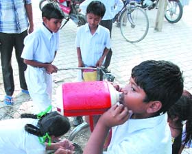 Children drink water to quench their thirst in Bathinda on Thursday