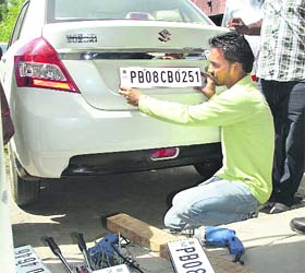 A high-security registration number plate being installed on a car in Jalandhar on Thursday