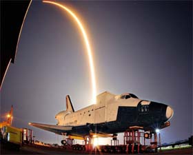 The Falcon 9 streaks over a model of Nasa's Space Shuttle at the Kennedy Space Center