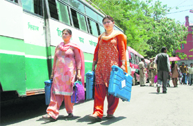 Employees carry electronic voting machines for the MC poll slated for May 27 in Shimla on Friday.
