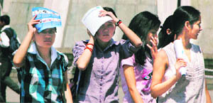 Girls shield themselves from scorching sun in Shimla on Friday. 