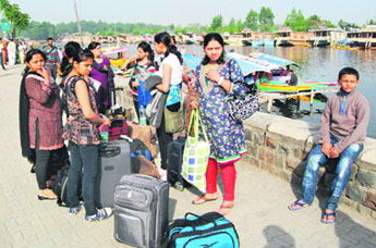 A group of tourists wait on the banks of the Dal Lake in Srinagar