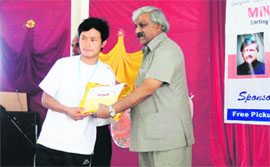 Uttarakhand Sports Minister Dinesh Aggarwal gives away a prize to a student in Mussoorie on Sunday.