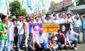Activists of the Socialistic Democratic Party protest against the hike in petrol prices outside the Press Club in Jammu on Sunday.