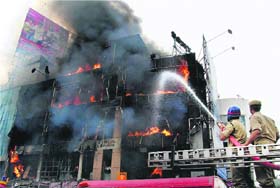 Firemen douse the fire that broke out in a shopping complex in Hyderabad on Sunday