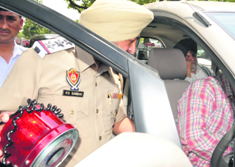 Police removes a red beacon from the car of a former minister Baldev Singh Maan in Mohali