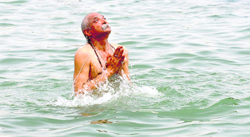 A man offers prayers to the sun while taking a dip in the Brahmasarovar.