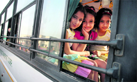 Kashmiri Pandit children pose happily after boarding a bus for Kashmir at Jagti township in Jammu on Monday.