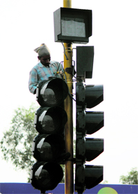 A worker instals a traffic signal at Satwari Chowk in Jammu on Monday.
