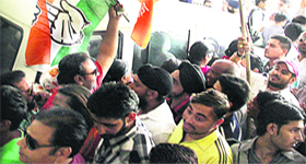 supporters of rival parties - the BJP and the Congress - move past each other carrying party flags during filing of nomination papers for the MC elections in Jalandhar on Monday. 