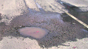 A potholed road in the ward.