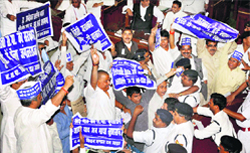 BSP members wave placards in the well of the UP Vidhan Sabha during the Governor's speech on Monday.  PTI