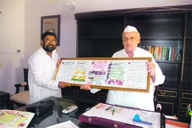 Shiv Prasad Dutt, secretary of Sewa Ashram and Bharat Welfare Society, shows posters to Uttarakhand Governor Aziz Qureshi in Dehradun on Tuesday